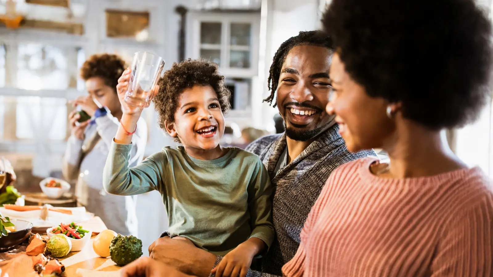 Happy black family enjoying meal Family spending time together as healthy coping strategies to support their mental well being and financial wellness
