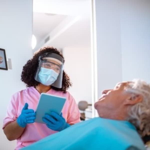 Dental practitioner talking to a patient.