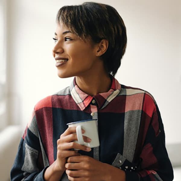 Woman in conference room holding coffee mug.