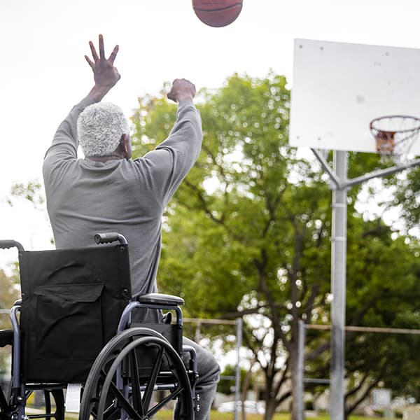 Man in wheelchair with short term disability playing basketball.