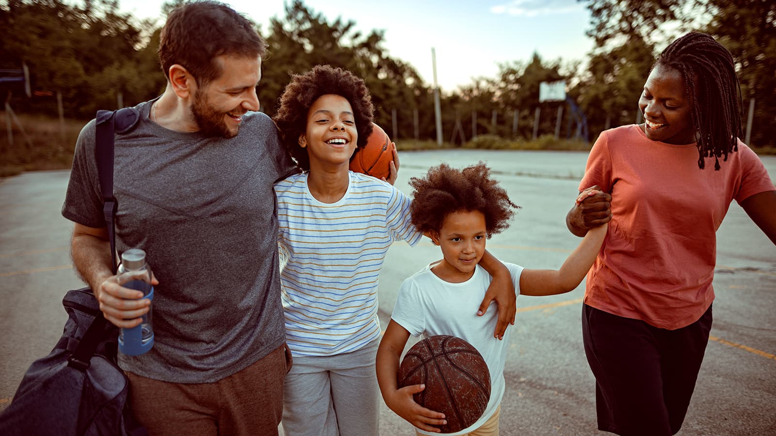 Family walking together holding basketball