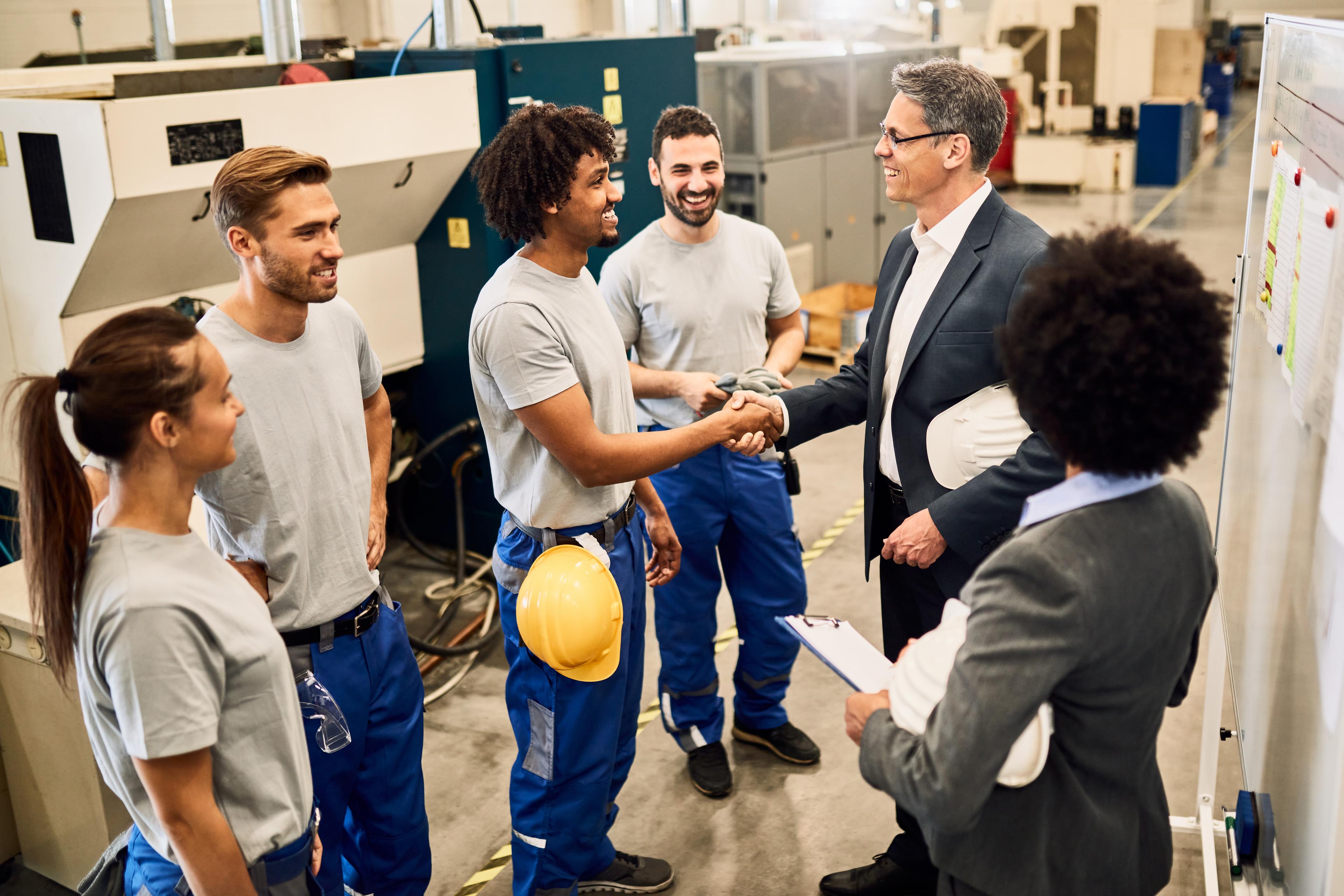 Happy company manager visiting a factory