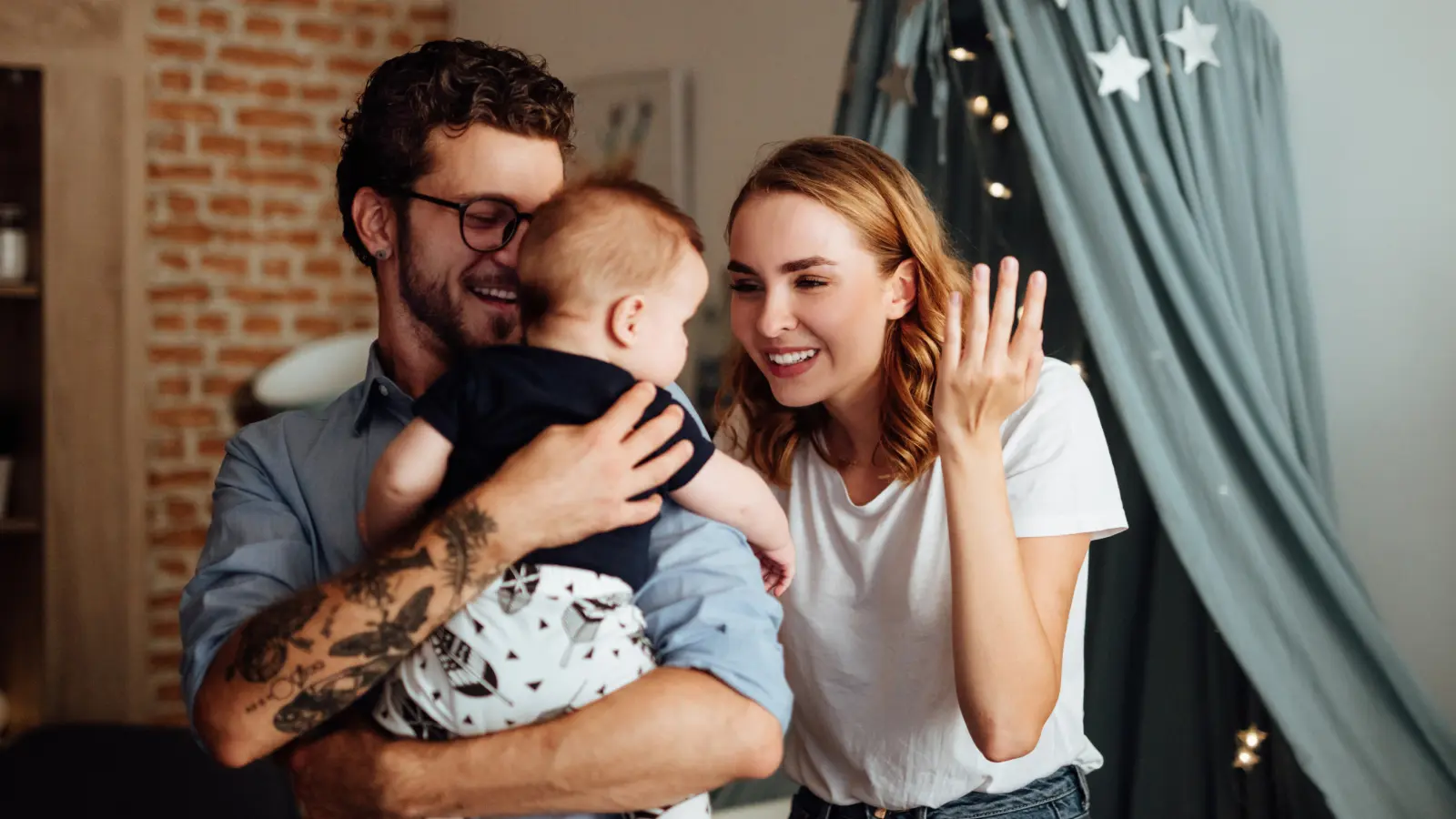 Mother and father playing with baby in nursery