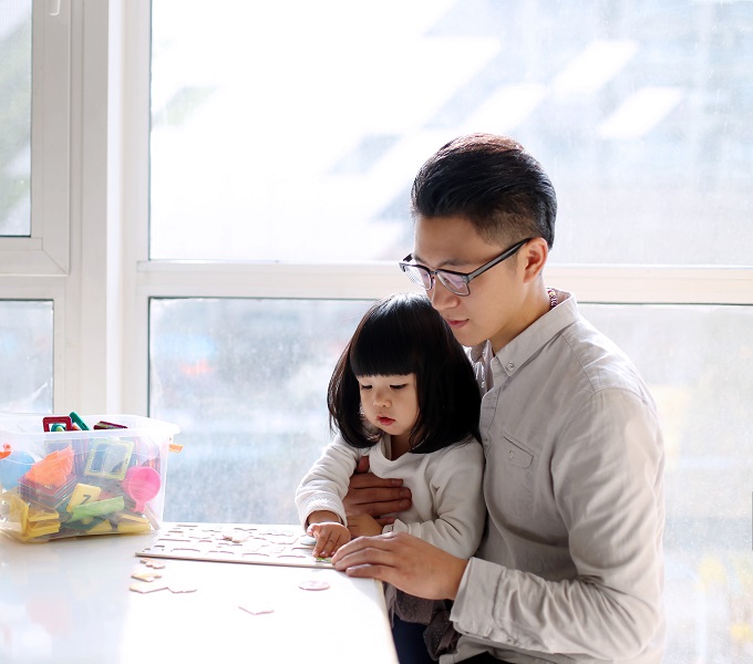 Man and daughter playing a board game.
