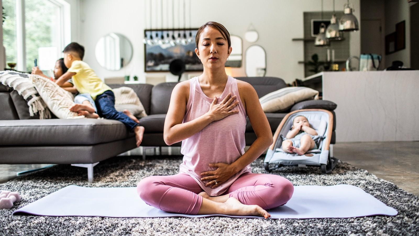 woman_stretching_on_a_yoga_mat_accompanied_by_three_children