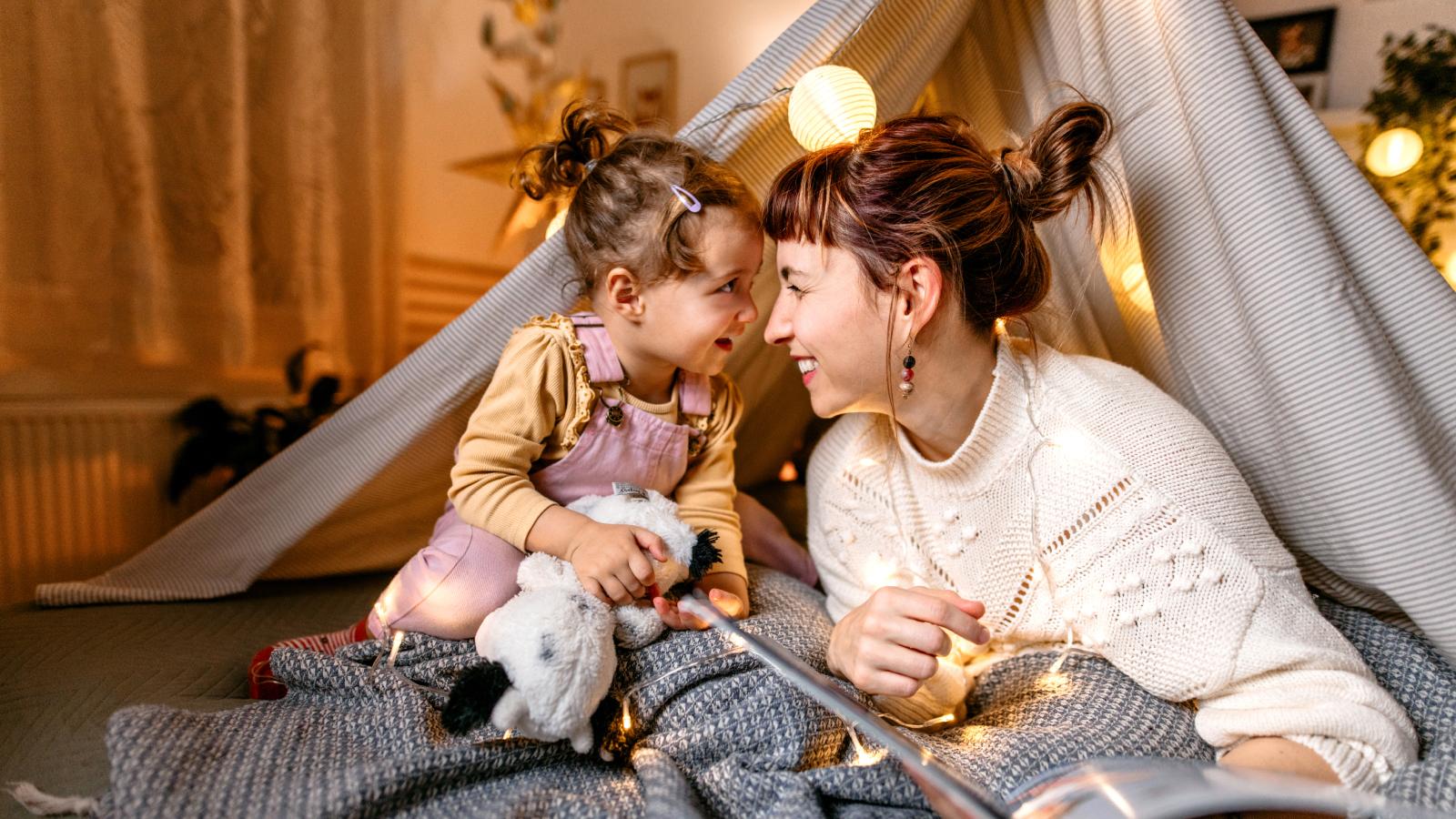 Mother and young daughter smiling at each other