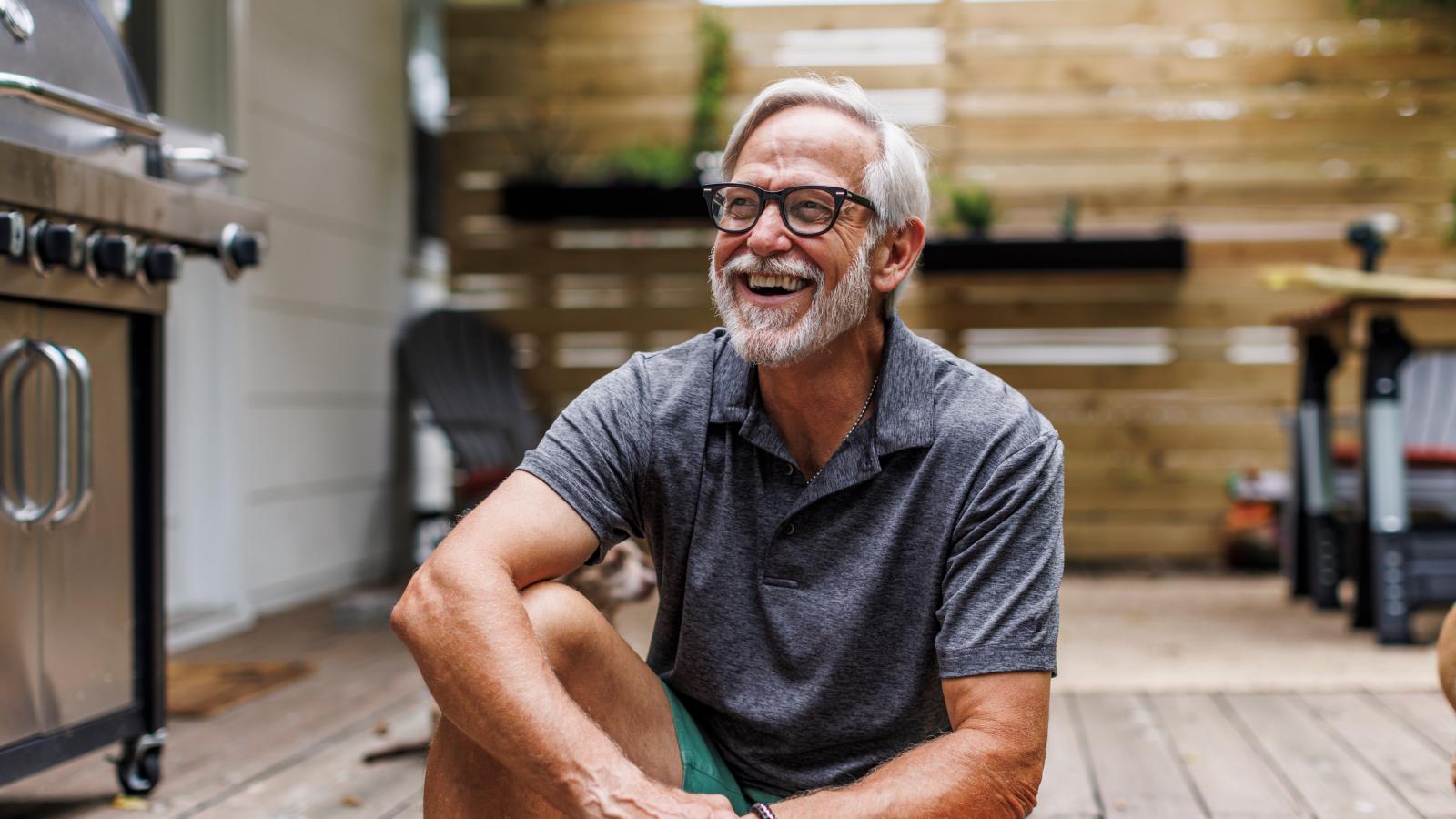 smiling-senior-man-sitting-on-porch-