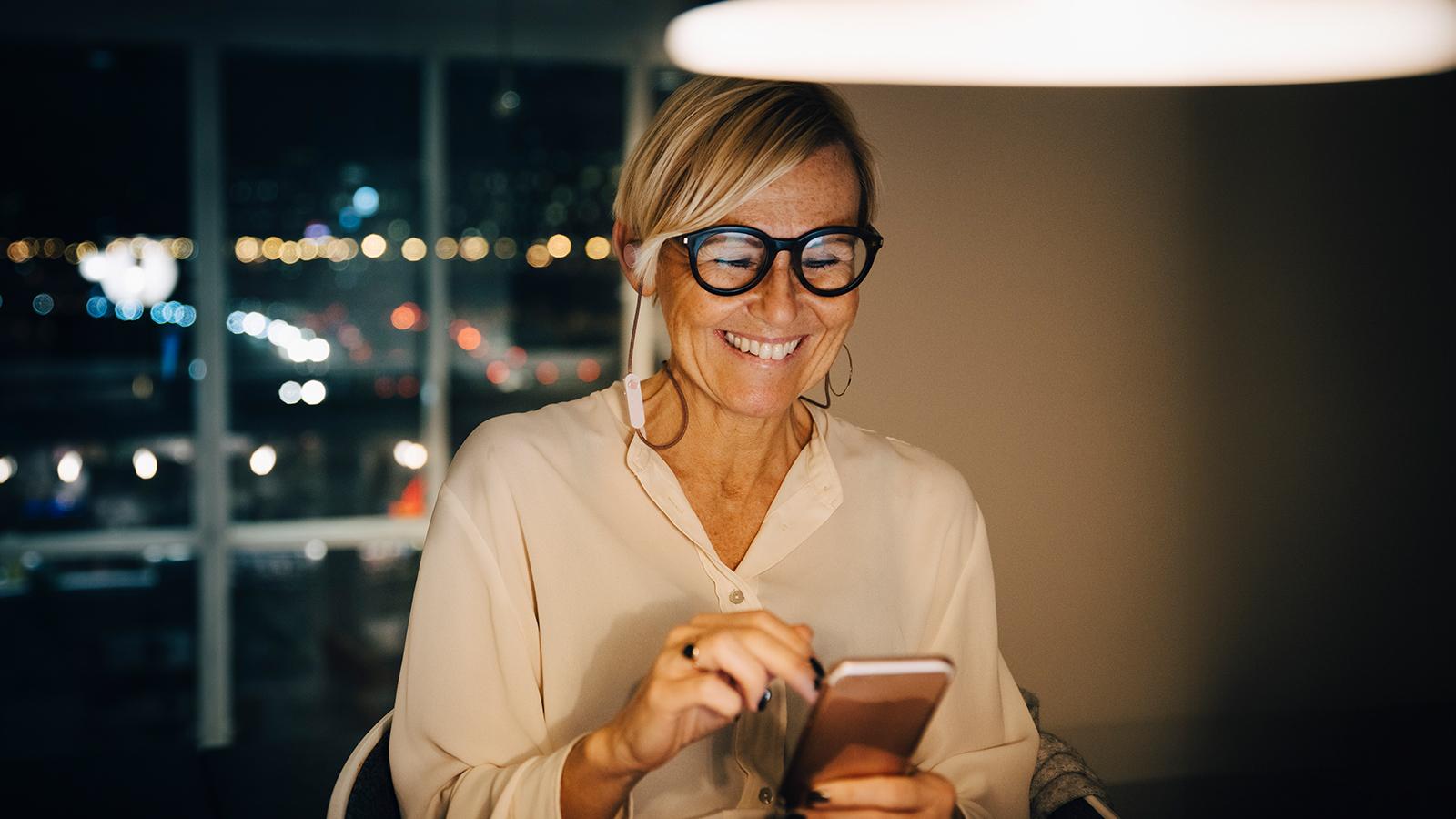 Woman smiling while looking at her phone
