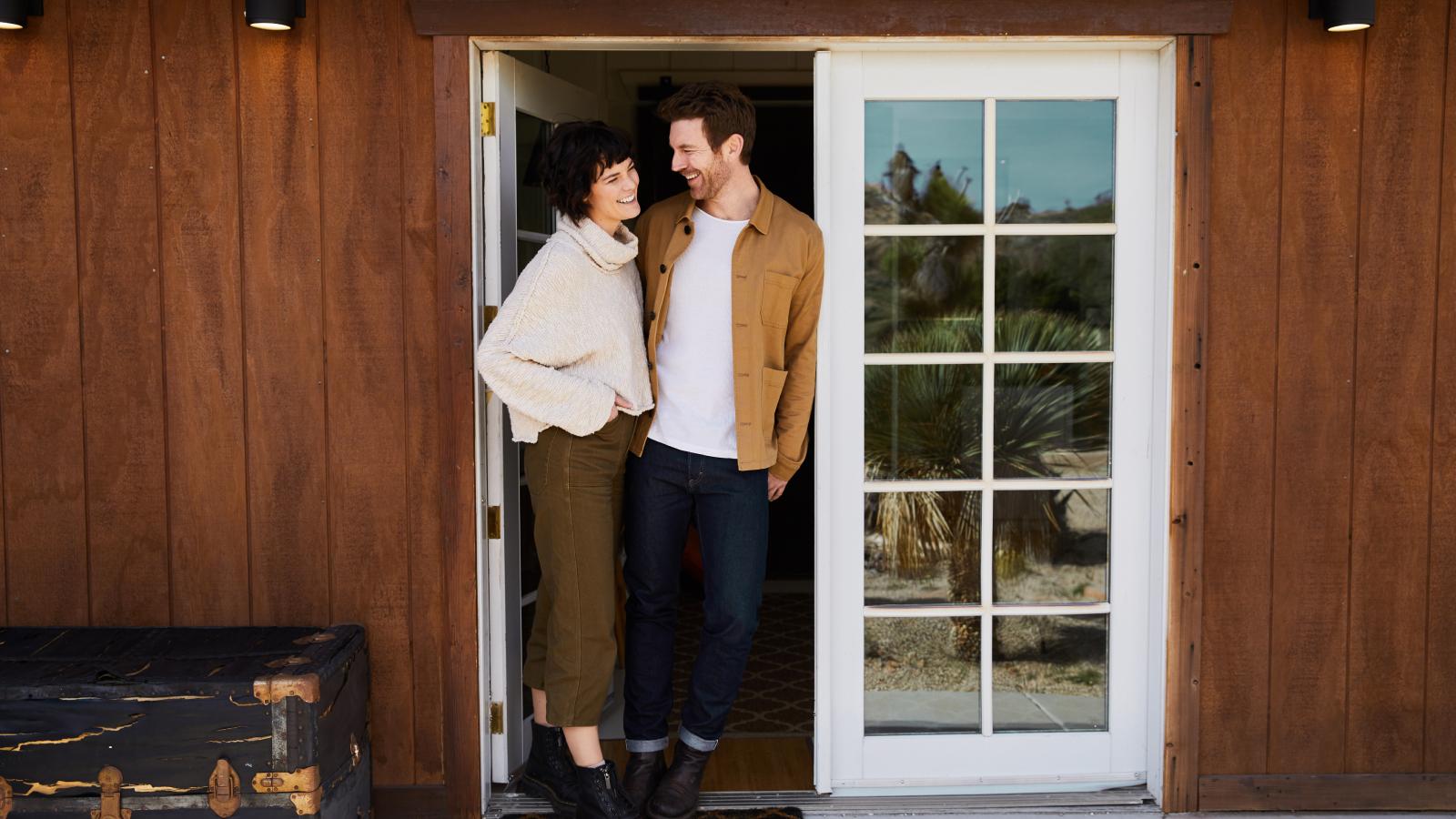 Couple happily standing on patio of home together
