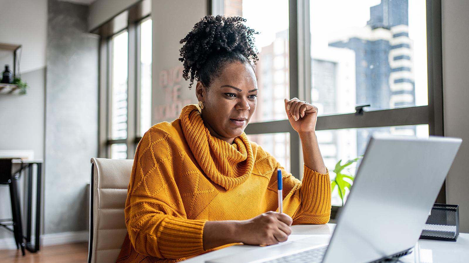 woman writing on a tablet at home
