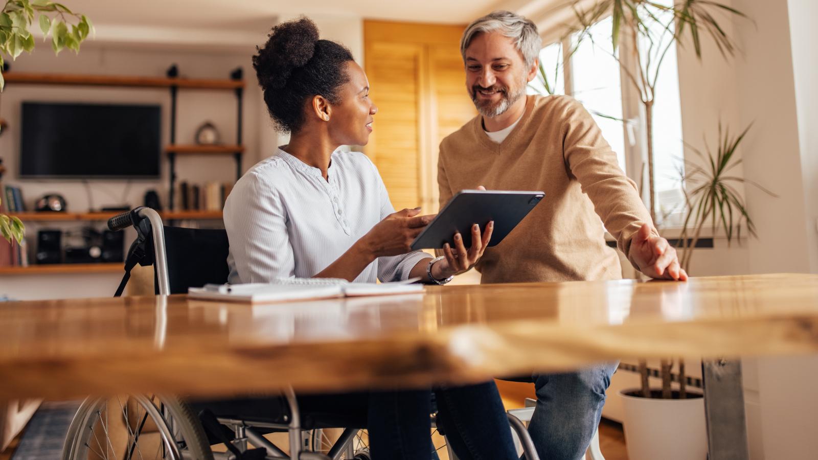 Woman in wheelchair working with colleague