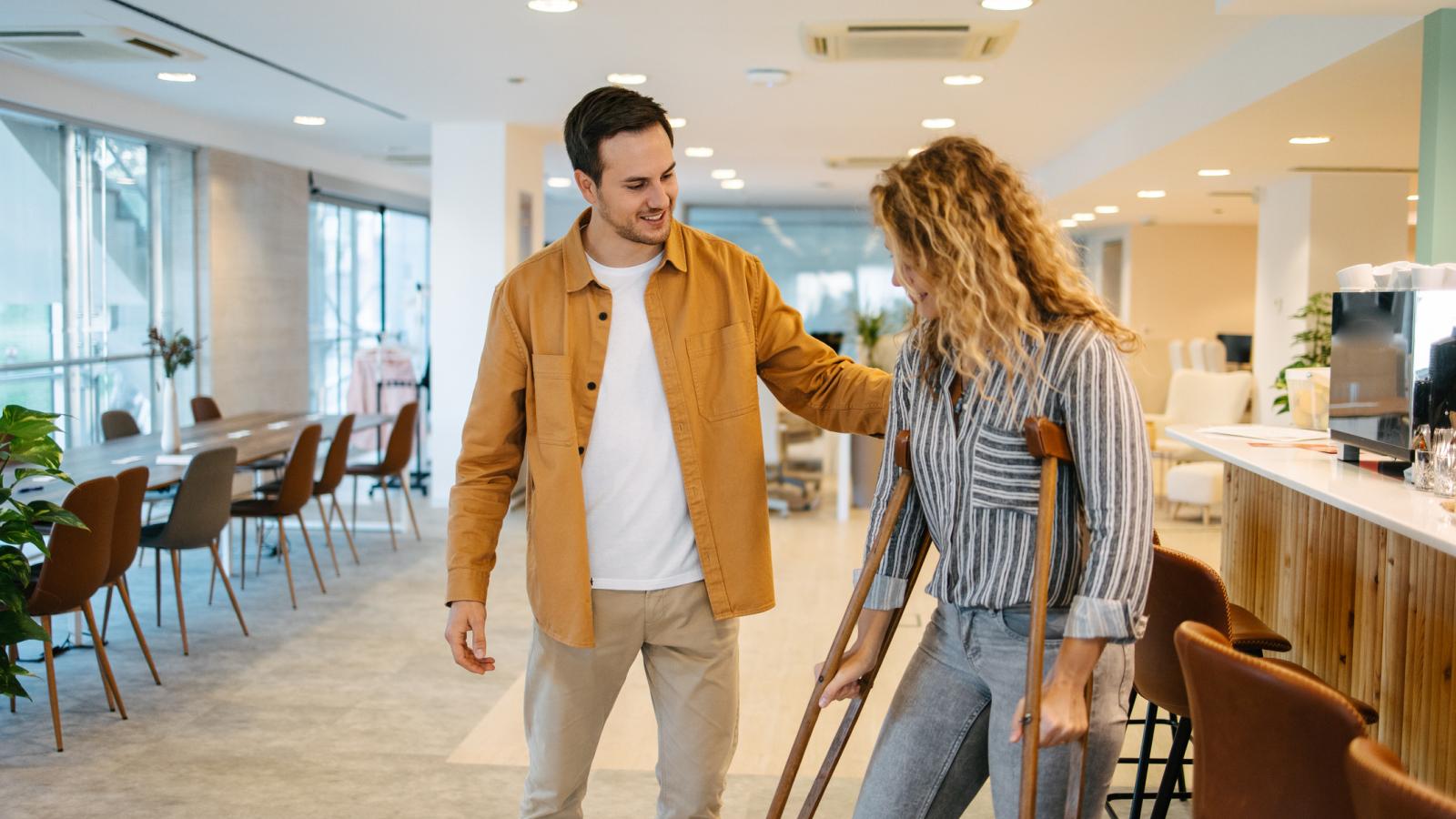 Man helping woman walking on crutches